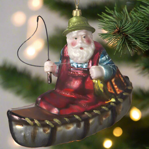 blown glass santa in canoe christmas ornament